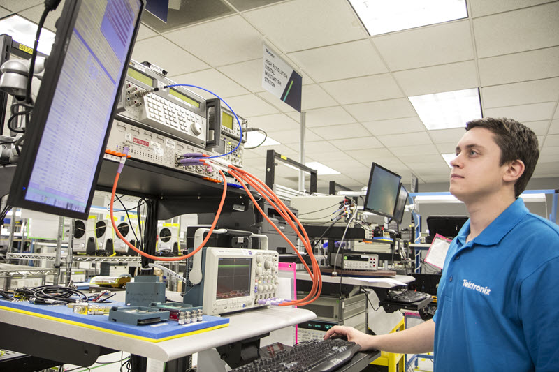 Tektronix employee servicing and calibrating an oscilloscope  
