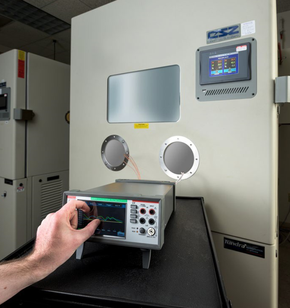 A photo showing a Tektronix DAQ6510 monitoring components inside an environmental test chamber.